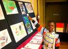 Malyk Reese, 8, points to his drawing titled “Happy Easter!” at the Youth Workers' Alliance Auction